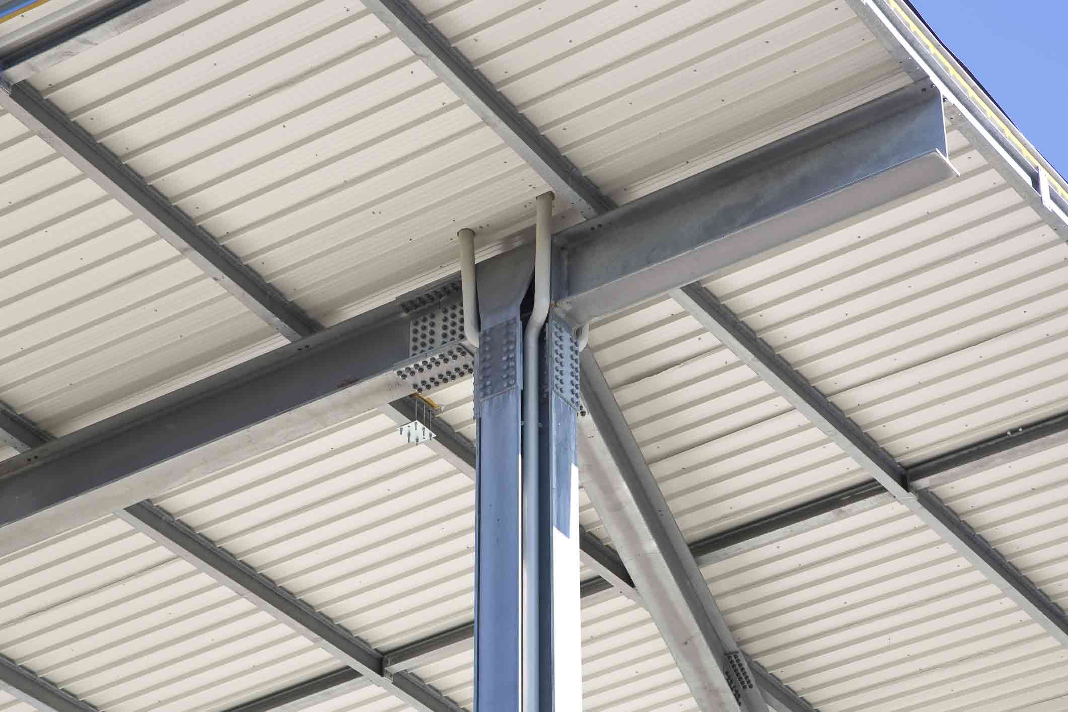 New metal roof with precast steel structure with pillars, steel beams and bolts in galvanized steel.